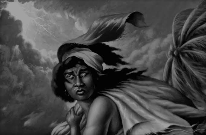 A powerful black-and-white illustration of Défilée La Folle, a historic Haitian woman known for her courage and compassion. She stands beneath a dramatic stormy sky, with winds sweeping through her flowing headscarf and garments. Her expression is fierce and determined, symbolizing strength, resilience, and the spirit of the Haitian revolution. Lightning flashes in the background, adding to the intensity and mysticism of the scene.